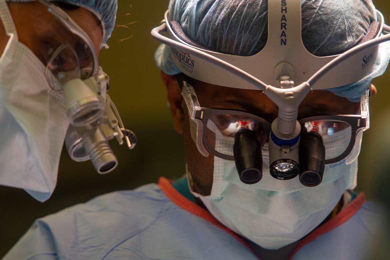 Two surgeons with microscopes