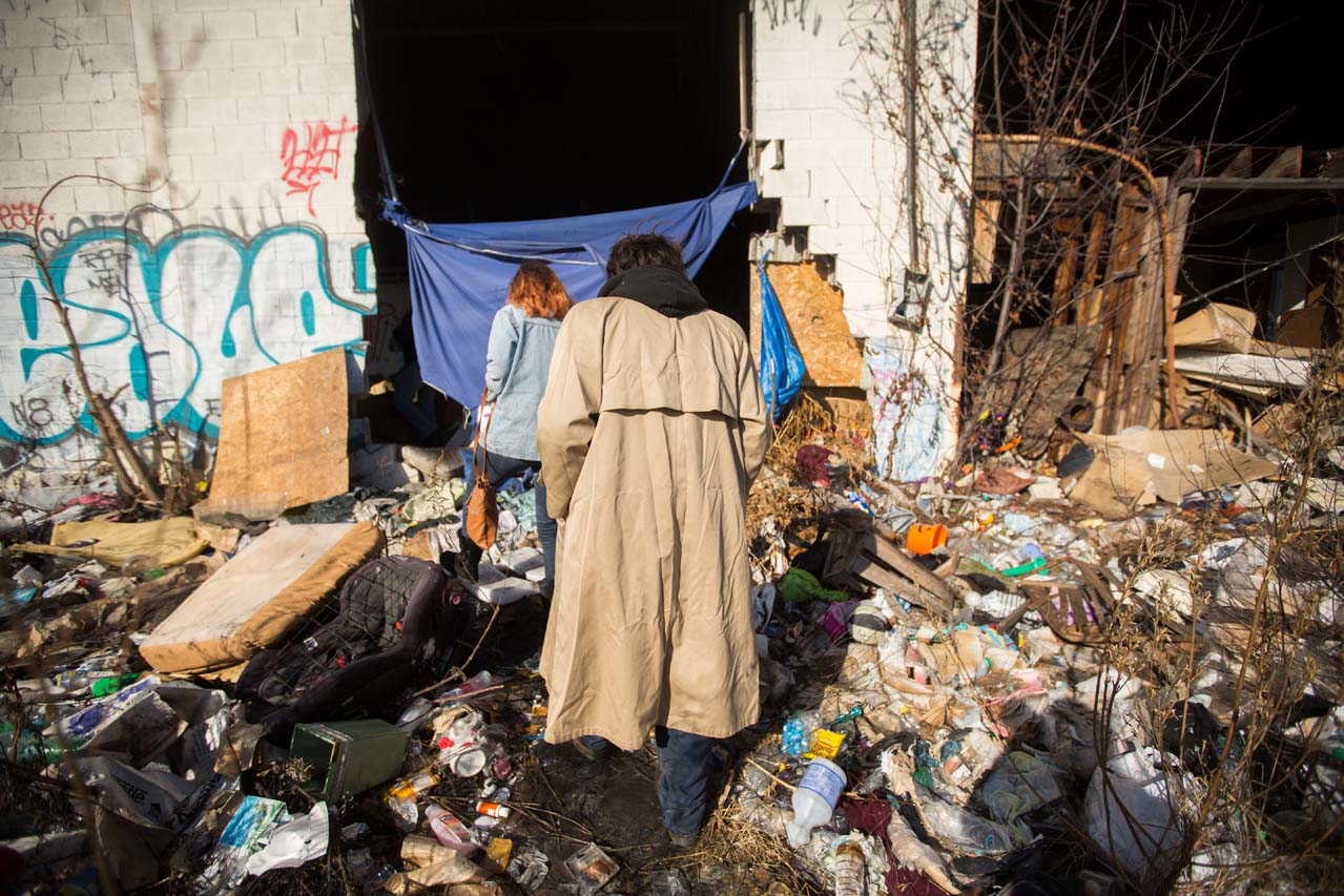 Two people walking through garbage